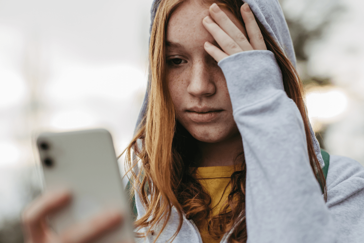 A Girl looks worriedly at her phone